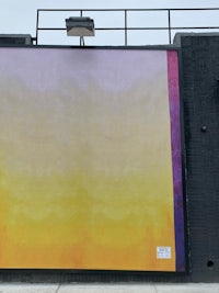 a large yellow and purple painting on the side of a building