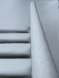 a close up of a railing covered in snow